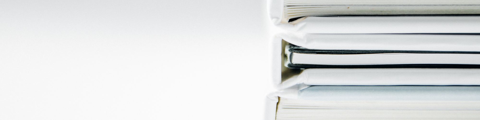 A stack of thick folders on a white surface