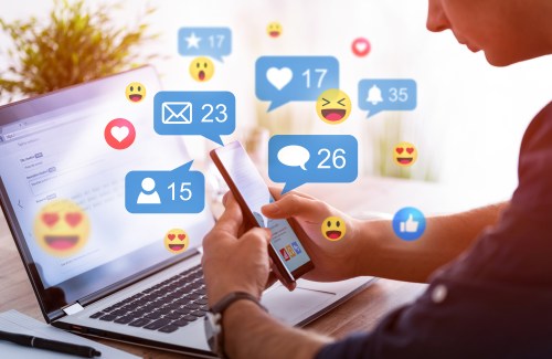 A person holding a phone with like button pop ups