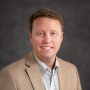 Headshot of man with tan blazer